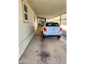 View of carport with painted walls and white vehicle parked on concrete at 18026 N Cave Creek Rd # 16, Phoenix, AZ 85032