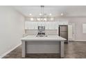 Modern kitchen features a large island, stainless appliances, and white cabinetry at 2000 N 36Th St # 35, Phoenix, AZ 85008