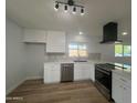 Renovated kitchen with stainless steel appliances, white cabinets, and quartz countertops at 2331 E Delgado St, Phoenix, AZ 85022