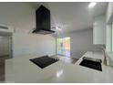 A close-up of the kitchen island showcasing a black range, a black sink, and waterfall countertops at 2331 E Delgado St, Phoenix, AZ 85022