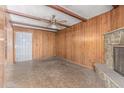 Living room features wood paneling, a stone fireplace, exposed beams, and a ceiling fan at 3302 W Turney Ave, Phoenix, AZ 85017