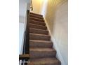 Carpeted staircase with a black railing and white wall, leading to the upper level of the home at 4236 S 46Th Pl, Phoenix, AZ 85040