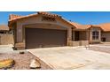 Single story home featuring a brown two car garage, tile roof, desert landscaping, and sidewalk leading to the front door at 4336 E Aspen Ave, Mesa, AZ 85201