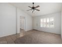 Bright living room with a ceiling fan, tile/carpet flooring, and view of the front yard through the front door at 4336 E Aspen Ave, Mesa, AZ 85201