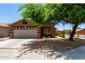 Welcoming single-story home with a well-maintained lawn and a convenient two-car garage at 6515 W Hughes Dr, Phoenix, AZ 85043