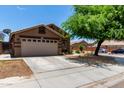 Inviting single-story home featuring a spacious driveway and neutral stucco exterior at 6515 W Hughes Dr, Phoenix, AZ 85043