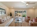 Cozy living room with neutral tones, plush carpeting, and a view to an enclosed patio at 10305 W Campana Dr, Sun City, AZ 85351