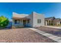 Exterior showcasing a one-story home with a stucco facade, gravel yard, and sidewalk leading to the front door at 1409 E Apollo Rd, Phoenix, AZ 85042