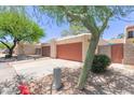 Exterior view of garages featuring stucco exteriors and low maintenance desert landscaping at 1822 S River Dr, Tempe, AZ 85281