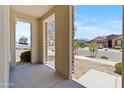 Inviting covered porch with stone-accented columns, providing a welcoming entrance to the home at 18854 W Poinsettia Dr, Surprise, AZ 85388