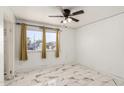Cozy bedroom with updated flooring, a ceiling fan, and a bright window with street views at 1916 W Tonto St, Phoenix, AZ 85009
