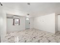 Bright living room with neutral paint, modern tile floors, and a window AC unit for added comfort at 1916 W Tonto St, Phoenix, AZ 85009