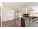 Bright kitchen with sliding door access, stainless steel dishwasher and modern cabinets over wood-look flooring at 19802 N 3Rd Ave, Phoenix, AZ 85027