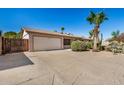 Inviting single-level home with an attached two-car garage, desert landscape and mature palm trees at 2018 W Taro Ln, Phoenix, AZ 85027