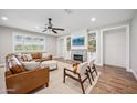 Cozy living room with a brick fireplace, built-in shelves, a ceiling fan, and a leather couch at 20198 E Rosa Rd, Queen Creek, AZ 85142