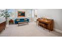 Stylish living room featuring a piano, blue velvet couch, and carpeted floors at 20198 E Rosa Rd, Queen Creek, AZ 85142
