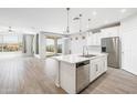 Bright, open-concept kitchen with a large island, stainless steel appliances, and stylish pendant lighting at 25727 N 161St Ave, Surprise, AZ 85387