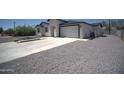 This modern home features a spacious concrete driveway and xeriscaped front yard, offering easy maintenance and a contemporary look at 2790 W Cholla St, Apache Junction, AZ 85120
