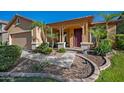 Inviting covered front porch framed by decorative columns and lush tropical landscaping at 3147 E Vallejo Dr, Gilbert, AZ 85298