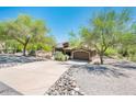 Spacious home with a long driveway, mature trees, desert landscaping, and an attached two-car garage at 33823 N 2Nd St, Phoenix, AZ 85085