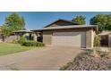 Brick home featuring a spacious two-car garage and an ample driveway for additional parking at 717 W Manhatton Dr, Tempe, AZ 85282