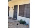 Close-up of a townhouse door with security bars and vintage sconce lighting at 7801 N 44Th Dr # 1036, Glendale, AZ 85301
