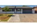 Charming single story home featuring a spacious driveway, lawn and a low white brick wall at 845 E Hampton Ave, Mesa, AZ 85204