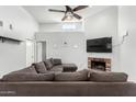 Light and airy living room featuring a cozy brick fireplace, a ceiling fan and neutral tones at 8940 W Olive Ave # 59, Peoria, AZ 85345