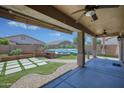 Inviting backyard oasis featuring a fire pit, artificial grass, and a covered patio with ceiling fans at 1101 W Oleander Ave, Queen Creek, AZ 85140