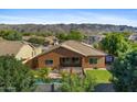 Aerial shot of backyard featuring a pool, grass, desert landscaping, and mountain views at 1506 E Branham Ln, Phoenix, AZ 85042