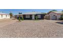 A single story home with gravel landscaping and a freshly painted dark gray exterior at 1527 W Roma Ave, Phoenix, AZ 85015