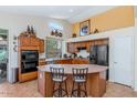 Beautiful kitchen with wooden cabinets, an island with seating, and stainless steel appliances, blending style and functionality at 18089 W Weatherby Dr, Surprise, AZ 85374