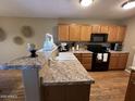 Well-organized kitchen featuring wooden cabinets, granite counters, and modern appliances at 19943 N 77Th Ave, Glendale, AZ 85308