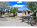 Inviting one-story beige home with a two-car garage and desert landscaping at 2638 W Sat Nam Way, Phoenix, AZ 85086