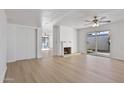 Bright living room featuring light wood flooring, a cozy fireplace, and a ceiling fan at 3218 W Clinton St, Phoenix, AZ 85029