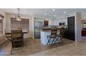 Bright kitchen features stainless steel appliances, island with bar seating, and breakfast nook at 42812 W Venture Rd, Maricopa, AZ 85138