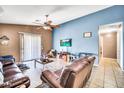 Spacious living room with a comfortable leather sofa and a large sliding glass door at 597 S 167Th Dr, Goodyear, AZ 85338