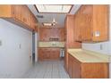 Functional kitchen space with ample wood cabinets and tile floors at 829 E Echo Ln, Phoenix, AZ 85020