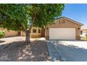 Charming single-story home featuring a two-car garage, desert landscaping, and a mature shade tree at 8319 E Portobello Ave, Mesa, AZ 85212