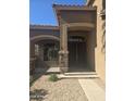 A close-up of the front door featuring stone detail, a covered porch, and desert landscaping at 955 W Laurel Ave, Gilbert, AZ 85233