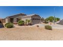 Beige single-Gathering home with a two-car garage and low-maintenance landscaping at 12132 W Caribbean Ln, El Mirage, AZ 85335