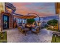Inviting patio with comfortable seating, a fire pit, an umbrella, and lovely landscaping at 13716 W Nogales Dr, Sun City West, AZ 85375