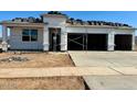 New construction featuring a three-car garage with contemporary design and desert landscaping at 15348 W Gray Fox Trl, Surprise, AZ 85387