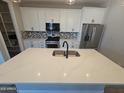 Modern kitchen with white cabinets, stainless steel appliances, and a large center island at 18871 S 209Th Way, Queen Creek, AZ 85142