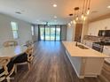 Open-concept living space with hardwood floors, a modern kitchen, and sliding doors to the pool at 18871 S 209Th Way, Queen Creek, AZ 85142