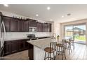 Modern kitchen with granite countertops, an island with seating, and stainless steel appliances at 19771 W Woodlands Ave, Buckeye, AZ 85326