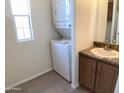 Convenient bathroom with stacked washer and dryer, and vanity with countertop at 2206 S Ellsworth Rd # 1736, Mesa, AZ 85209