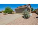 Wide driveway leading to a two-car garage, surrounded by desert landscaping at 22610 W Mohave St, Buckeye, AZ 85326