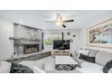 Comfortable living room features a stone fireplace, ceiling fan, and modern decor at 2615 N Hayden Rd # 114, Scottsdale, AZ 85257