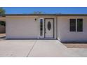 A front door is surrounded by brick detail and sidelight windows. The home has neutral colored stucco at 3701 W Villa Maria Dr, Glendale, AZ 85308